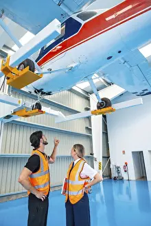 Teamwork In Aviation Industry Drucke: Aviation technician and pilot collaborate