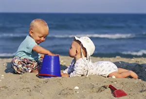 Young Children Playing Drucke: Two babies playing at the beach