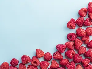 Healthy Eating Picture Drucke: Background of raspberries. Raspberry on blue background with copy space