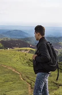 Adventure Travel Photography Drucke: Backpacker looking at a hill in the distance