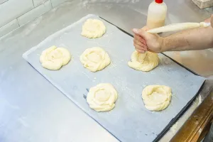 Small Business Bakery Drucke: Baker of bakery in the workshop workshop of artisan bakery preparing the buns before baking
