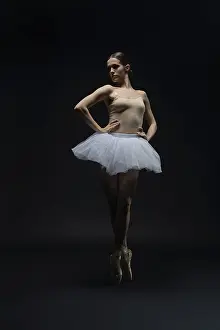 Ballet Dancer Drucke: A ballet dancer displays elegance in a dark studio