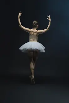 Ein Balletttänzer tanzt elegant in einem weißen Tutu.