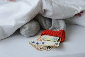 Savings Stocking Drucke: Banknotes in stocking under duvet