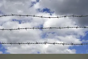Blue Sky Europe Drucke: Barbed wire, blue sky with clouds in the background