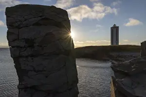 Icelandic Coastal Scenery Drucke: Basalt column and lighthouse in the backlight