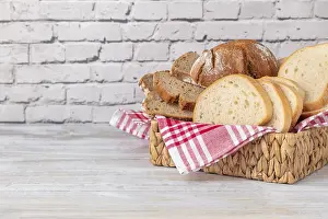 Diverse Bread Types Drucke: A basket with different types of bread on a brick wall