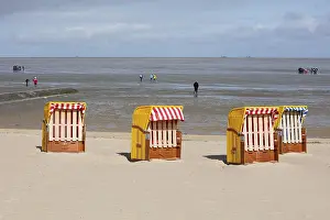 Low Tide Germany Drucke: Beach chairs on sandy beach and back mudflat strollers