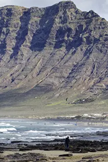 Mirador Risco De Famara Viewpoint Drucke: Beach with rocks and cliffs (Risco de Famara) in the background