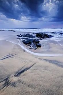 Spanish Coastal Scene Drucke: Beach with stones, waves and clouds