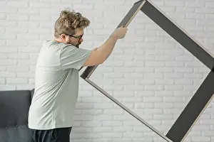 European Architectural Style Drucke: Bearded millennial man assemble his bookcase
