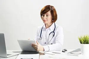 Medical Diagnosis Drucke: Beautiful doctor using tablet computer in office