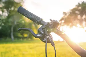 Electric Bicycle Europe Drucke: Bicycle handlebars with handle in the sunset