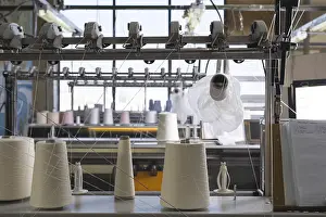 Industrial Building Architecture Drucke: Big spools with white thread at rewinding machine view