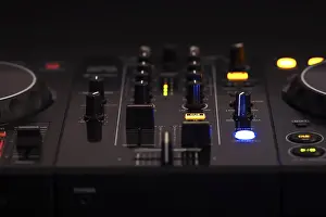 Professional Audio Equipment Drucke: A black DJ mixer with various buttons and knobs