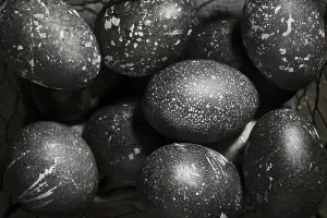 Gray Background Images Drucke: Black painted eggs for Easter in a basket