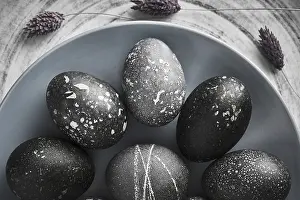Christian Holiday Traditions Drucke: Black painted eggs for Easter on a blue plate