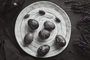 Christian Holiday Traditions Drucke: Black painted eggs for Easter on a blue plate