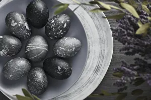 Christian Holiday Traditions Drucke: Black painted eggs for Easter on a blue plate