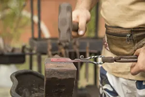 Industrial Workshop Setting Drucke: Blacksmith working on metal on an anvil