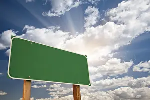 Konzeptuelle Kunst Drucke: Grüne Straßenschild über dramatischem blauen Himmel mit Wolken und Sonnenstrahlen