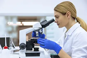 Medical Care Specialist Drucke: Blonde scientist working with microscope