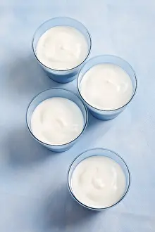 Studio Background Photos Drucke: Four blue cups of yoghurt