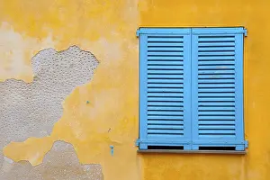 Deserted House Background Drucke: Blue shutter on yellow plaster wall