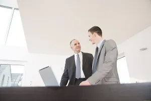 Businessman In Suit Drucke: Boss and trainee working together on a computer