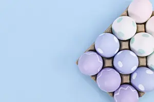 Decorative Easter Eggs Drucke: Box of pastel colored easter eggs on blue background with copy space