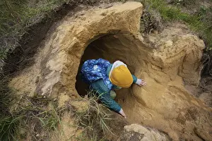 Eastern European Boy Drucke: Boy with backpack explore limestone stone cave at mountain