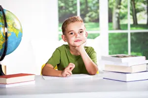 Single Person Studying Drucke: Boy with books at a table
