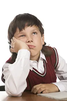 Educational Institution Image Drucke: Boy dreaming at the table isolated on white