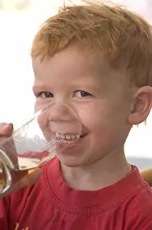 Happy Child Portrait Photo Drucke: Boy drinks out of a glas