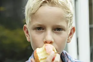 Apple Health Benefits Drucke: Boy eating an apple