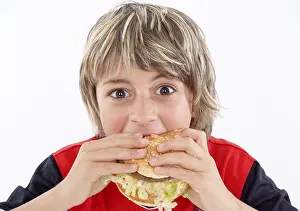 Unhealthy Snack Choices Drucke: Boy eats hamburger