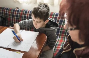 Educational System Image Drucke: Boy do his homework. Notebook