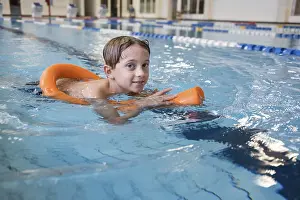 Water Sports Training Drucke: The boy learning to swim in the indoor pool