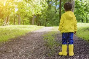 Caucasian Ethnicity Children Drucke: The boy on the path in the Park stands with his back to the camera