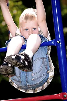 Boy Looking At The Camera Drucke: Boy playing on the playground