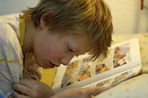 Relaxing With A Book Drucke: Boy reading in bed
