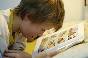 Boy Reading In Bed Drucke: Boy reading in bed