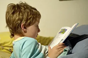 Boy Reading In Bed Drucke: Boy reading in bed