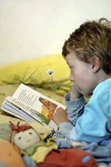 Boy Reading In Bed Drucke: Boy reading in bed