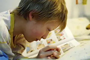Boy Reading In Bed Drucke: Boy reading in bed