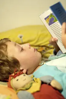 Boy Reading In Bed Drucke: Boy reading in bed