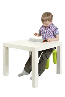 White Background Isolated Photo Drucke: Boy with a Tablet PC on the desk in the studio on a white background