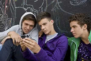 Group Of Friends Drucke: Three boys sitting with their backs against a wall
