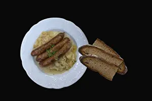 Dark Background Food Images Drucke: Bratwurst with cabbage and bread on a black background