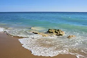 Spanish Coastline Drucke: Breaking waves on a sandy beach with a rock